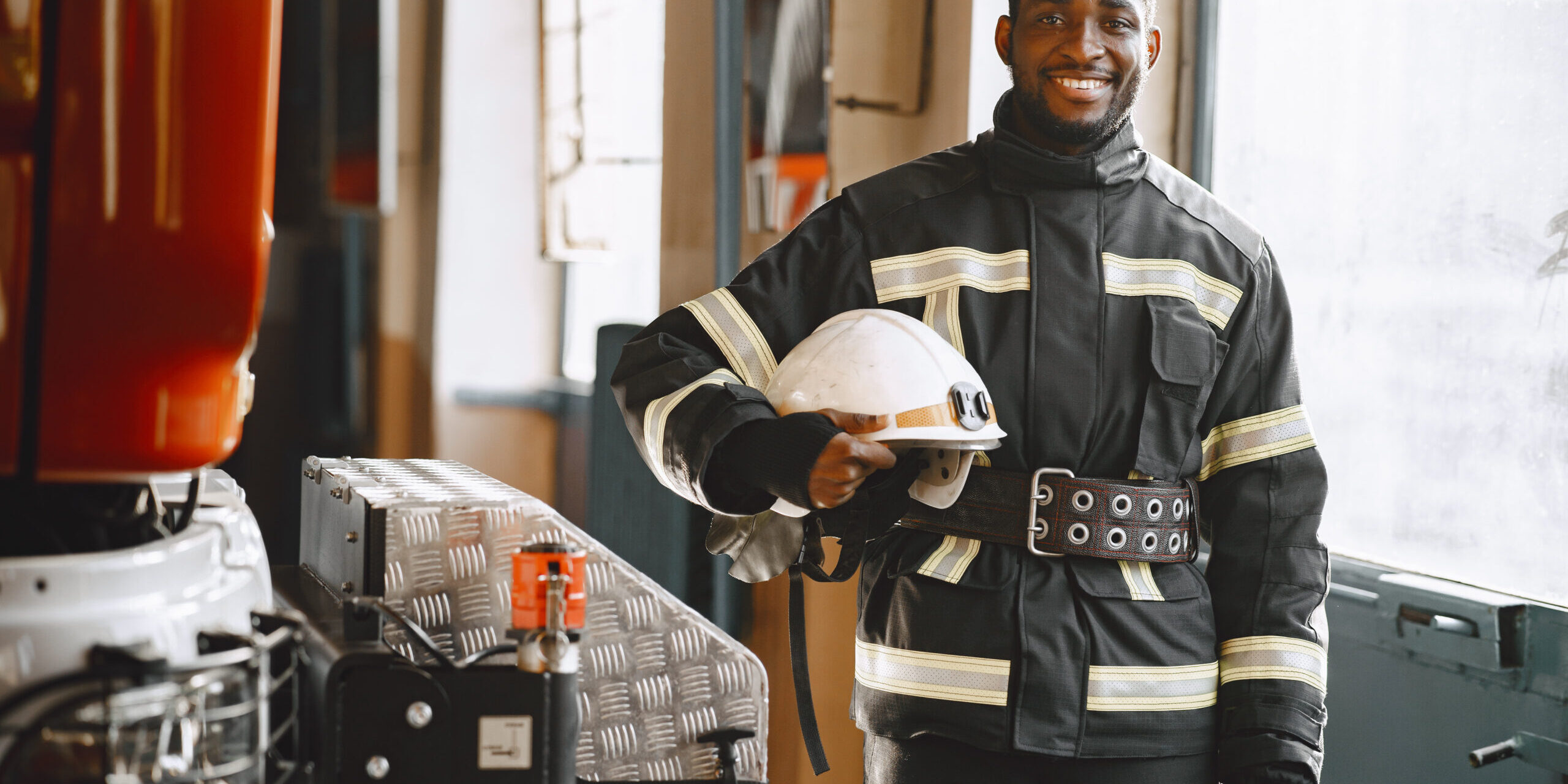 Portrait of a firefighter standing in front of a fire engine